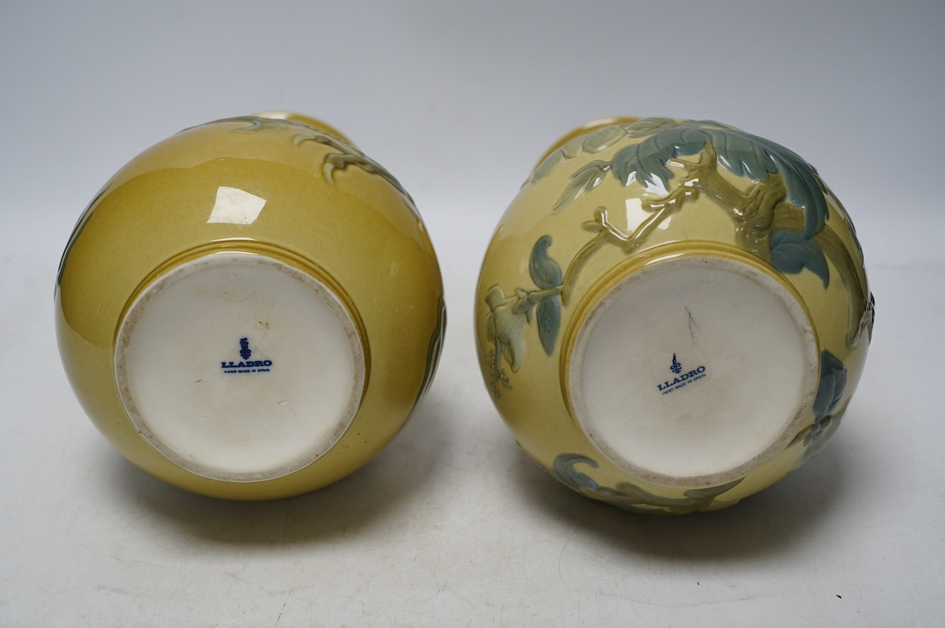 Two Lladro vases decorated in relief with dragons and birds, 26cm high. Condition - good